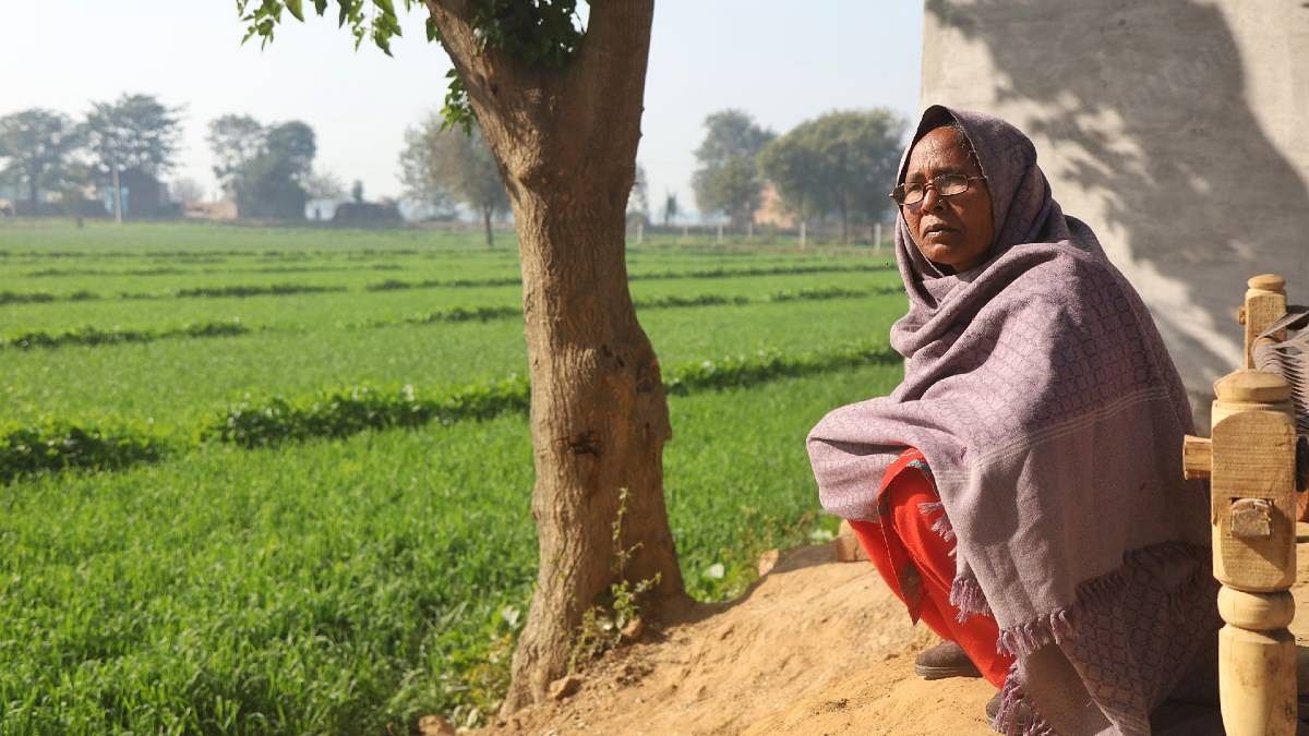 The deceased's mother sits outside their house, overlooking their fields. | Photo: Manisha Mondal | ThePrint