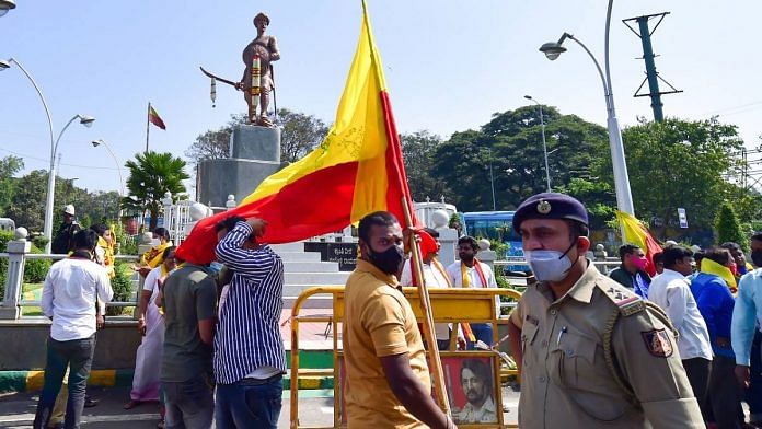 Protesters carry a Kannada flag in front of a Sangolli Rayanna statue in Bengaluru on 19 December | PTI