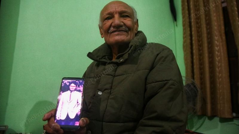 नरसिंहानंद के पिता मास्को में अपने युवा बेटे की एक तस्वीर दिखाते हुए/मनीषा मोंडल/दिप्रिंट