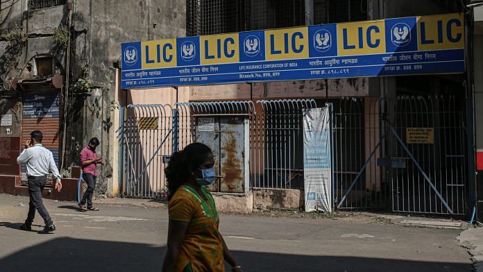 Pedestrians pass a LIC branch office in Mumbai | Photo: Dhiraj Singh | Bloomberg
