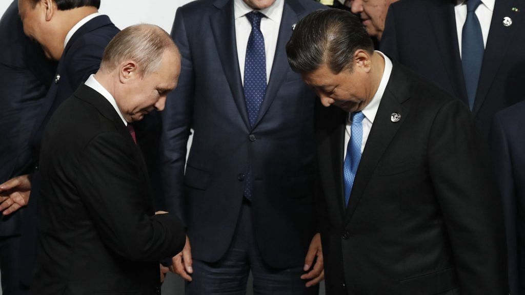 Russian President Vladimir Putin (left) and Chinese President Xi Jinping (right) attend a photo session during the G-20 summit in Osaka, Japan in 2019