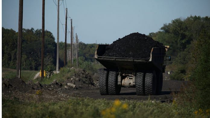 A Euclid earth-moving dump truck carries coal down a haul road on a coal mine| Photographer: Luke Sharrett/Bloomberg