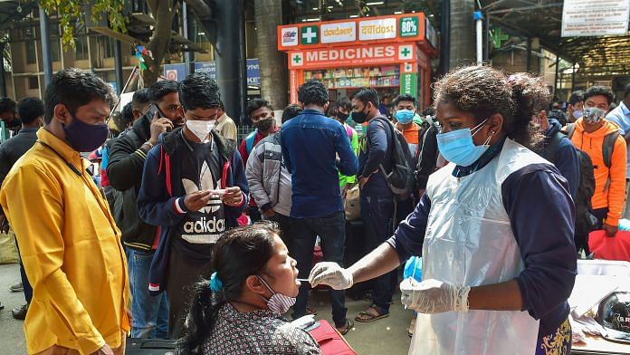 A health worker collects a swab sample of a passenger for Covid test at Krantiveer Sangoli Rayanna (KSR) railway station in Bengaluru, on 5 January 2021 | PTI Photo