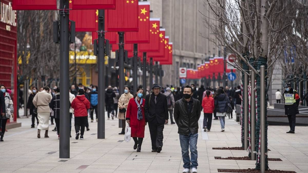File photo of pedestrians walking down a road in Shanghai on the day of the Lunar New Year last year. | Photo: Qilai Shen | Bloomberg