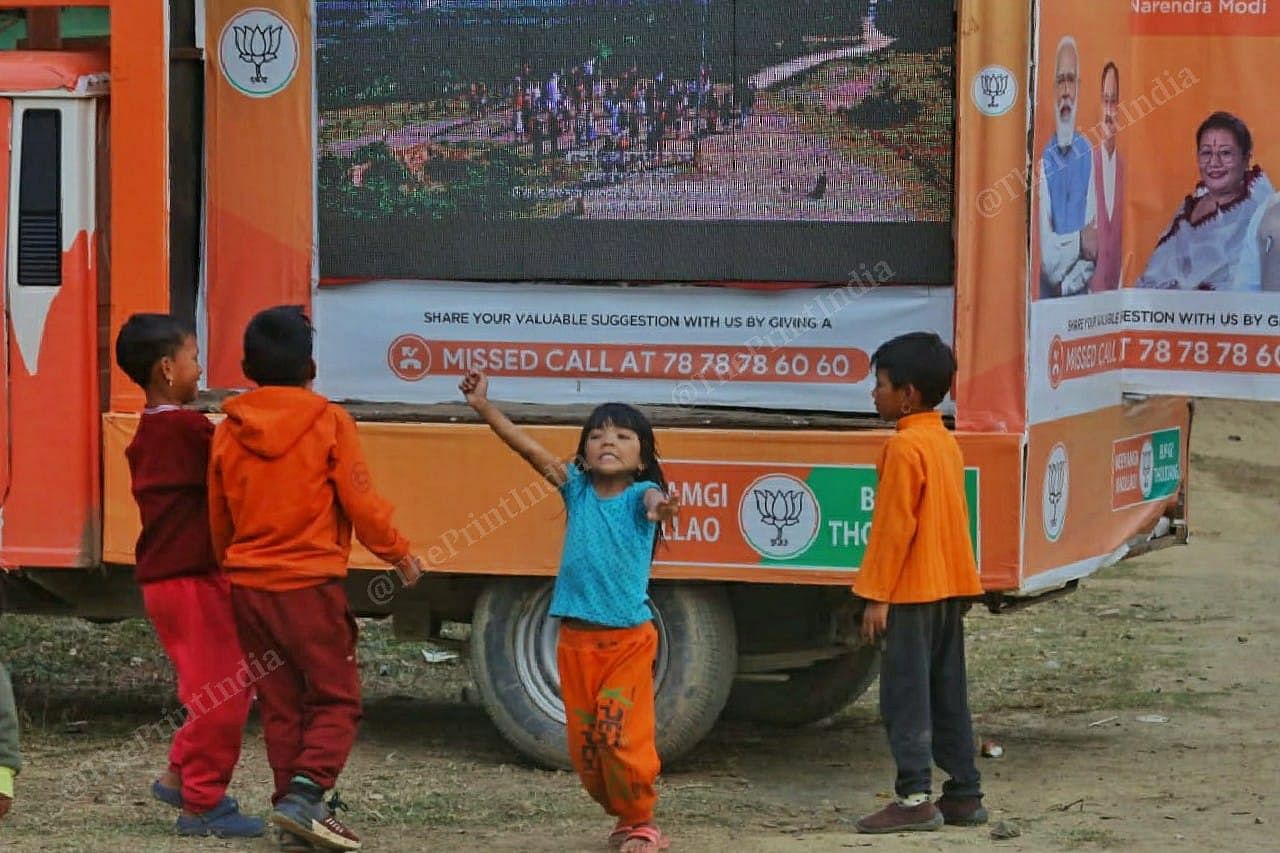 Children dance near a BJP van in Thanga, Bishnupur district, as it plays the party's election song | Photo: Praveen Jain | ThePrint