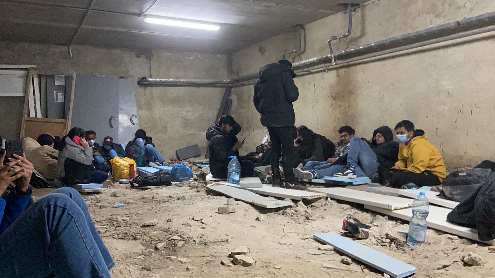 Indian students sit on wooden planks and check their phones in an underground bunker in Kharkiv, Thursday | Kwaish Thapa | By special arrangement