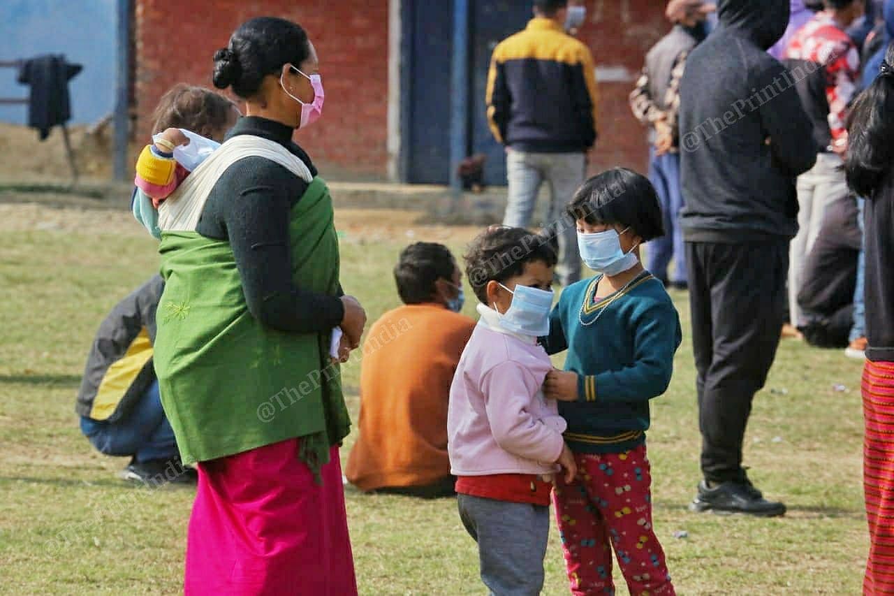 A woman with her childrens stating in a queue to cast their vote at Takhel primary school in Lamlai constituency | Praveen Jain | ThePrint