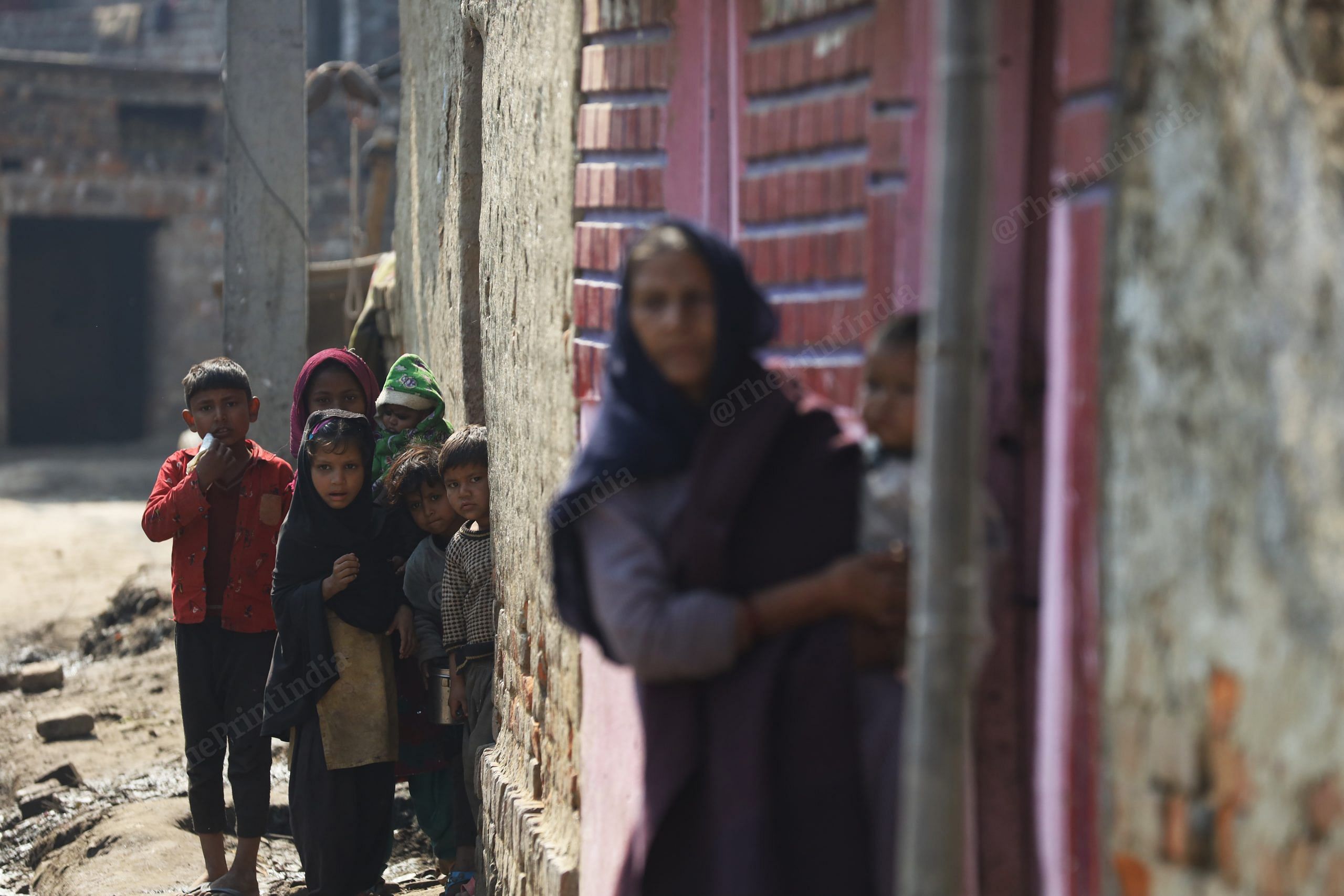 Children in Dularpur village stand outside their home. | Manisha Mondal | ThePrint
