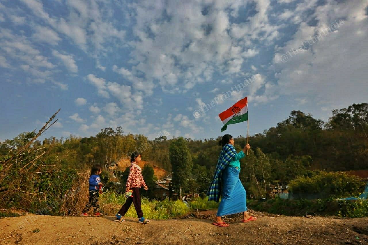 A Congress supporter carries the party flag in the Loktak lake area | Photo: Praveen Jain | ThePrint