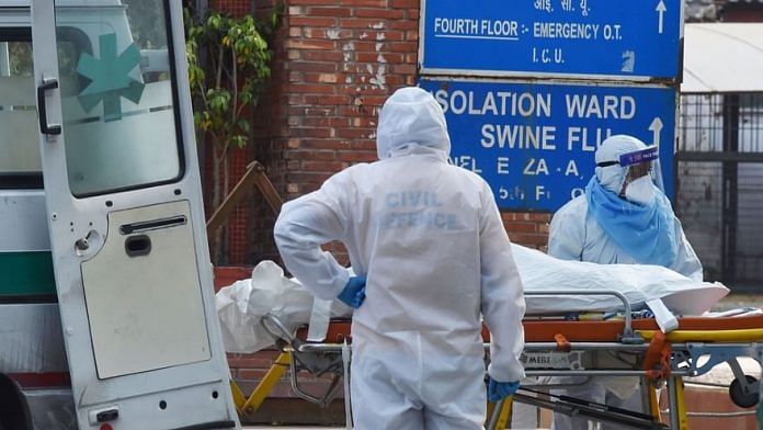Health workers in protective suits shift a body of a Covid victim into a van | PTI file photo