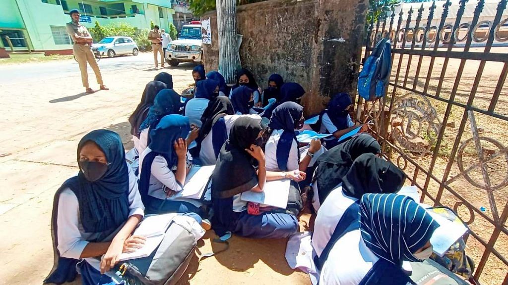 Students wearing hijab sit outside their school as the school authorities denied entry for wearing a hijab or scarf in Karnataka's Kundapura of Udupi district, on 4 February 2022 | PTI