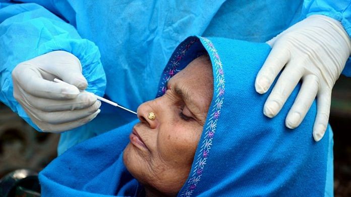 File photo of a healthcare worker collecting nasal swab sample of a woman for Covid-19 testing in Jammu | Photo: ANI