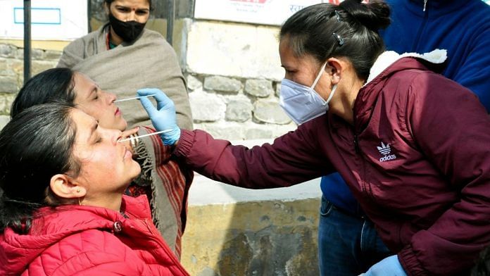 A healthcare worker collects nasal swab sample of a woman forCovid-19 test, at Regional Hospital, in Kullu on 14 February 2022 | Photo: ANI