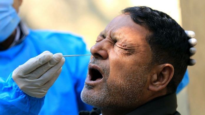 A healthcare worker collects swab sample of a man for Covid test in Jammu, on 16 February 2022 | ANI photo