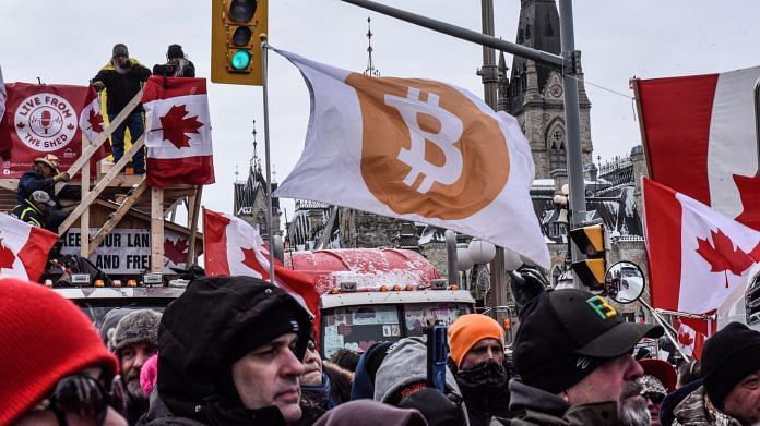 A protester holds a Bitcoin flag during a demonstration in Ottawa on 12 February 2022