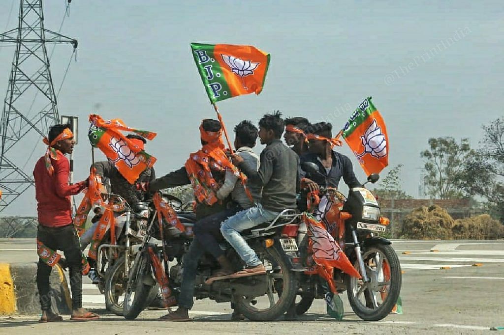 Supporters of BJP carry flags during a rally | Photo: Praveen Jain | ThePrint