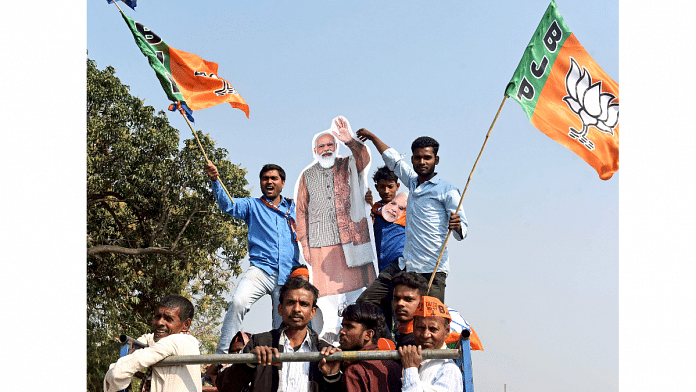 BJP supporters holding a cutout of PM Modi attend a public meeting by him for the seventh and last phase of UP Assembly elections in Varanasi, on 5 March 2022 | ANI photo