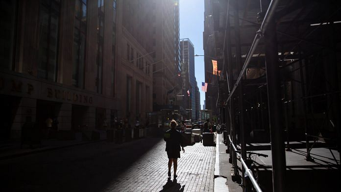 A pedestrian on Wall Street near the New York Stock Exchange (NYSE) in New York | Photo: Michael Nagle | Bloomberg