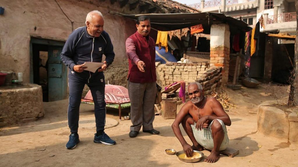 RSS workers woo a resident of Singhpur, Varanasi district, ahead of the last two phases of UP assembly elections | Suraj Singh Bisht | ThePrint