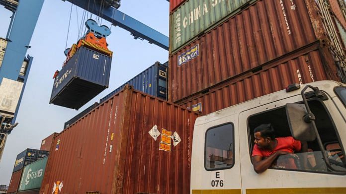 A truck driver watches a reach gantry crane move a shipping container at the Jawaharlal Nehru Port in Navi Mumbai | Representational image | Bloomberg