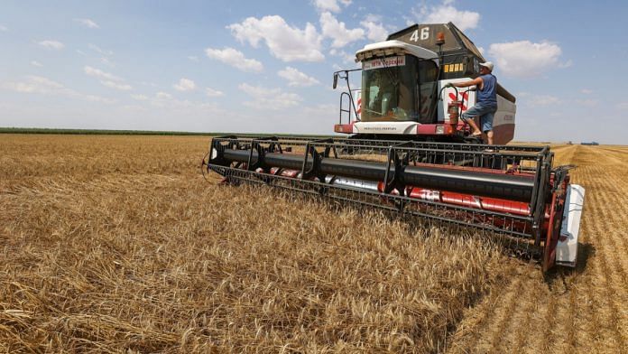An Acros combine harvester, manufactured by Rostselmash OJSC, drives through a wheat field during the summer harvest on a farm in Tersky village, near Stavropol, Russia| Bloomberg