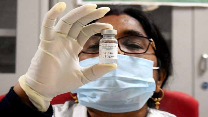 Representational image of a healthcare worker with a vial of Covaxin during a vaccination drive in Prayagraj | ANI