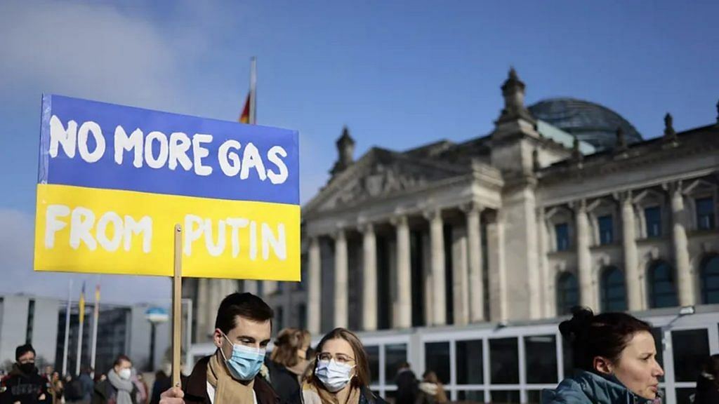 A sign saying "No More Gas From Putin" passes the Reichstag building in Berlin, Germany on 27 February 2022 | Hannibal Hanschke/Getty Images via Bloomberg