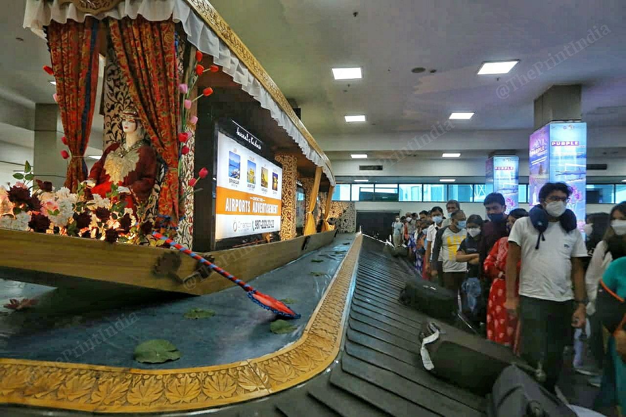 A shikara model greets passengers waiting by baggage claim at Srinagar airport | Photo: Praveen Jain | ThePrint