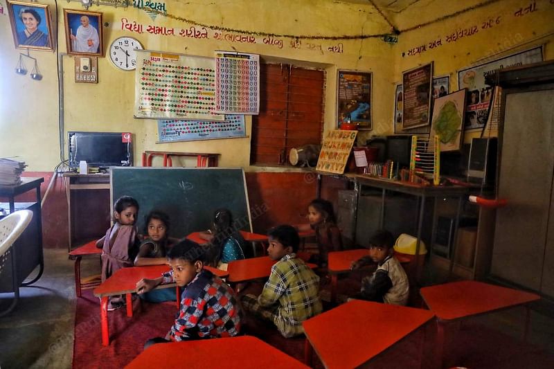 Students wait patiently for their turn to be taught at Dungari Faliya prathmikshala at Simaliya village, Mahisagar district. Their teacher is busy with older students in another room. An unused computer can be seen in the background | Manisha Mondal | ThePrint