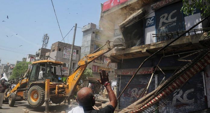 A bulldozer being used to carry out the demolition drive in Delhi's Jahangirpuri Wednesday | Suraj Singh Bisht | ThePrint