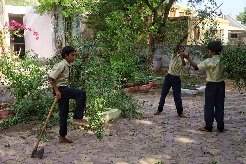 Students clear out some overgrowth at the Shree Shakti Nagar government lower primary school at Dhavda Nana village in Kachchh district | Manisha Mondal | ThePrint