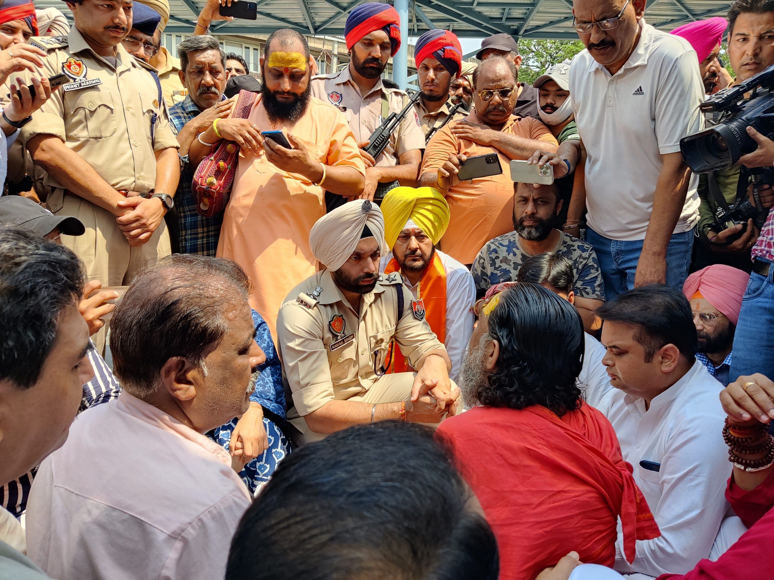 Nanak Singh speaks to Panchanand Giri Maharaj outside the Kali Mata temple. | Urjita Bhardwaj