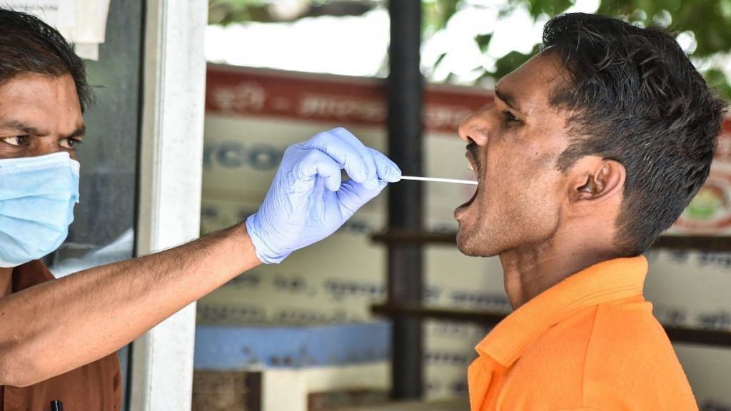 A health worker collects swab samples of residents for Covid testing in Gurugram, on 15 April 2022 | PTI