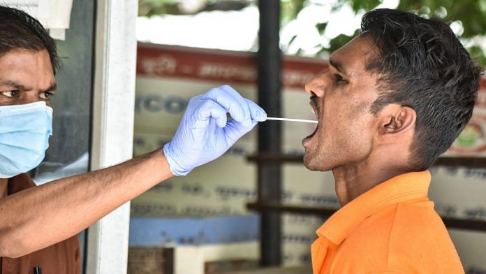A health worker collects swab samples of residents for Covid testing in Gurugram, on 15 April 2022 | PTI