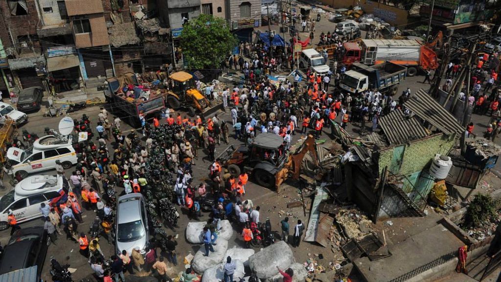Bulldozers raze structures in the area that saw communal violence during a Hindu religious procession on Saturday at Jahangirpuri, New Delhi. | Photo : Suraj Singh Bisht | ThePrint