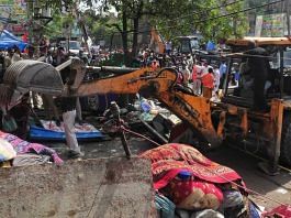 A bulldozer razes structures in the area that saw communal violence during a Hindu religious procession on Saturday at Jahangirpuri, New Delhi | Photo: Suraj Singh Bisht | ThePrint