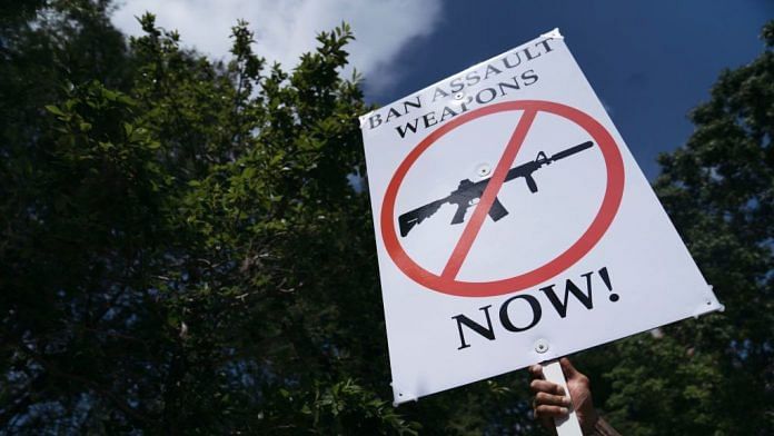 A gun-control advocate holds a sign across from the National Rifle Association Annual Meeting during a protest in Houston, Texas on 27 May 2022. | Photo: Eric Thayer | Getty Images via Bloomberg