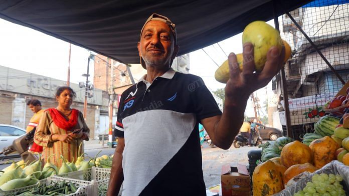 Abdul Rashid Malik, father of SunRisers Hyderabad's pace bowling sensation Umran Malik, holds up fruits at his stall in Jammu | Photo: Praveen Jain | ThePrint