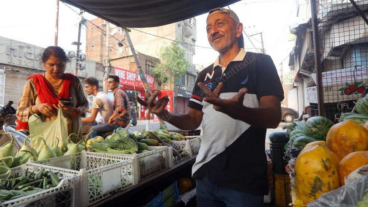 Abdul Rashid with a customer at his fruit and vegetable stall | Photo: Praveen Jain | ThePrint