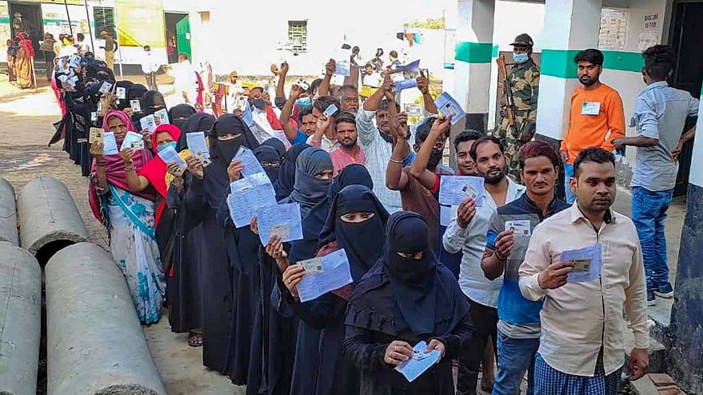 File photo of Muslim voters holding their identification cards to cast their vote in the UP elections | PTI