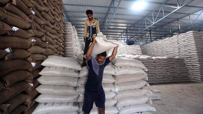 A worker carries a sack of wheat grain to store it inside a warehouse during harvest season, Bhopal, 6 May | Credits: ANI Photo