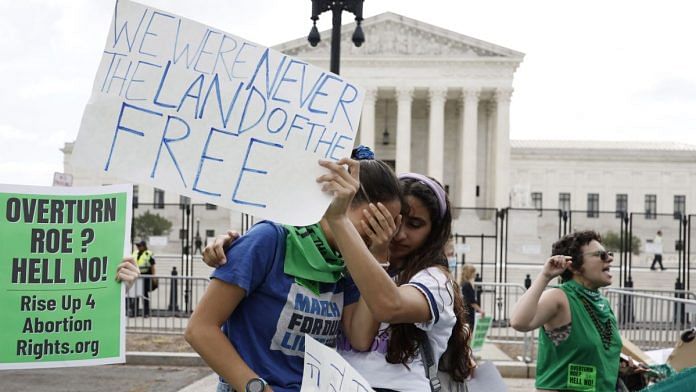 Abortion rights demonstrators hold signs outside the US Supreme Court in Washington, DC, on 24 June 2022 | Bloomberg