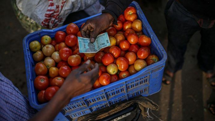 A vendor sells tomatoes at a wholesale vegetable market in Bengaluru | Bloomberg file photo