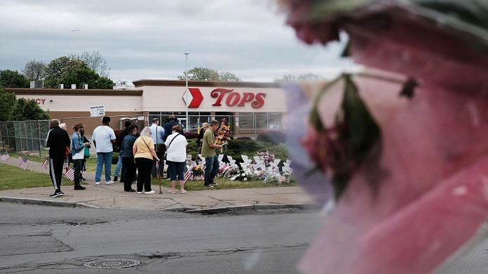 People gather at a memorial for the shooting victims outside of Tops grocery store in Buffalo, New York, on 20 May 2022 | Bloomberg