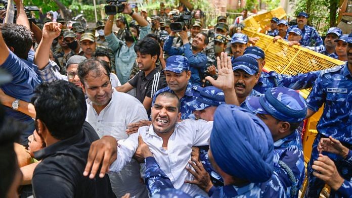 Security personnel stop members of IYC during protest outside the CPI(M) headquarters over vandalisation of Rahul Gandhis office in Wayanad, in New Delhi, on 25 June 2022 | PTI