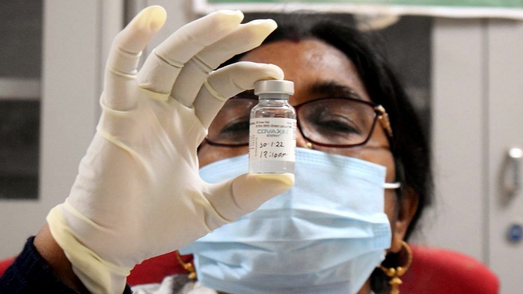 Representational image of a healthcare worker showing a vial of Covaxin | ANI