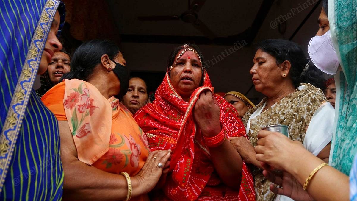 Kanhaiya Lal Teli's wife Yashoda (in red) being comforted by others | Photo: Manisha Mondal | ThePrint