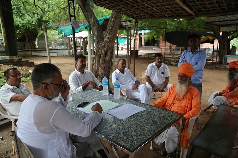 Sant Bijnath, named as an accused in the FIR, confers with his lawyer | Suraj Singh Bisht | ThePrint