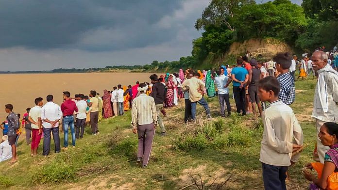 People gather along the banks of Yamuna river after a boat capsized at Marka area in UP's Banda district, on 11 August 2022 | PTI