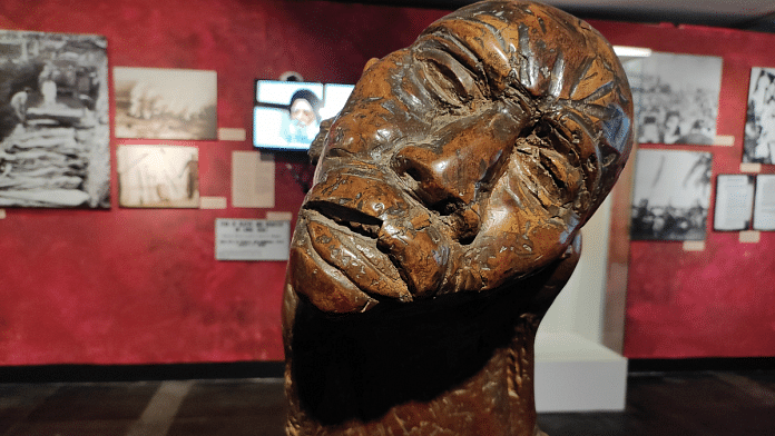 'Lonely Pilgrim' by SL Prasher is a wood sculpture that speaks directly to the viewer. With deep despair on his face, the migrant asks when his pain will come to an end | Sanskriti Bhatnagar/ThePrint